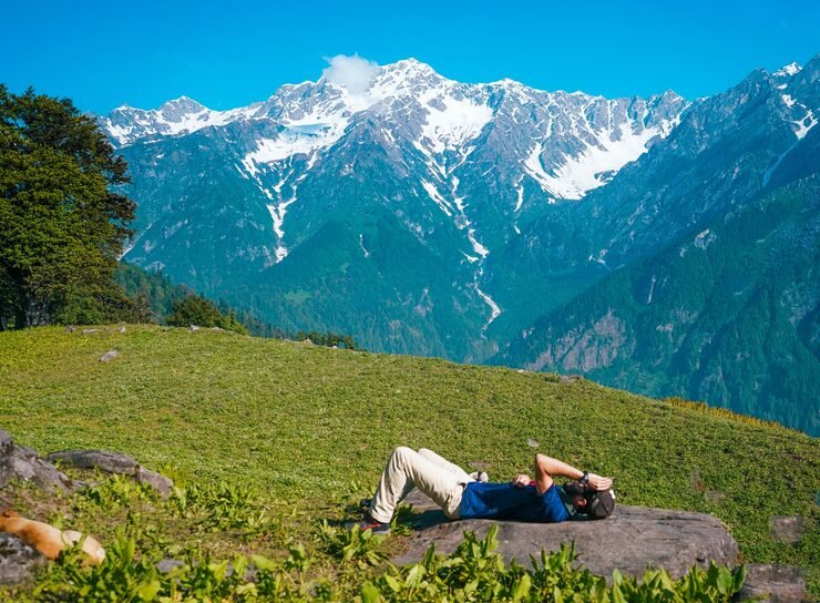 lonely male lying down sunbathing meadow with mountains 181624 30235