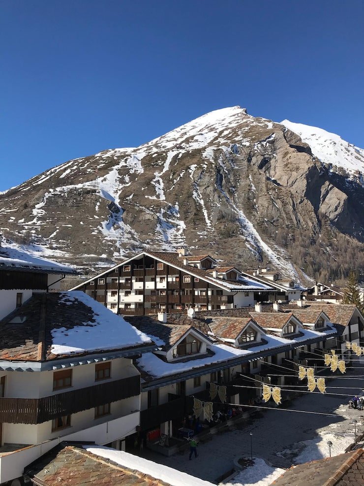 snow covered houses by mountain against clear blue sky 1048944 9529738