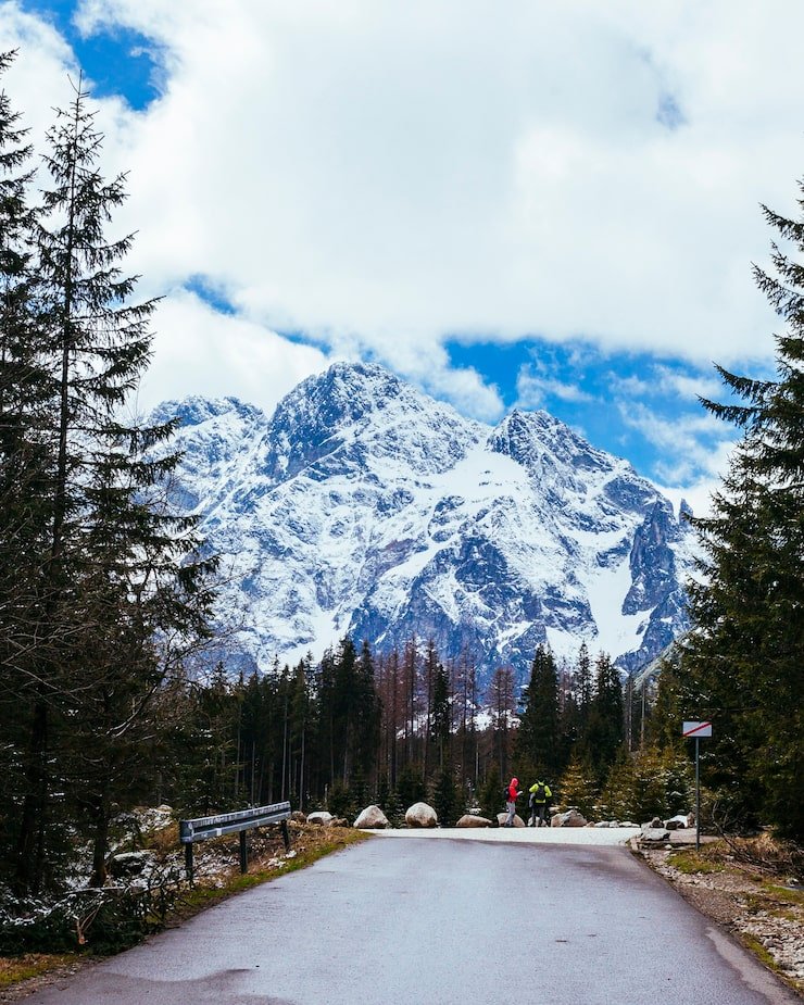two tourist standing road near snowy mountain 23 2148153673