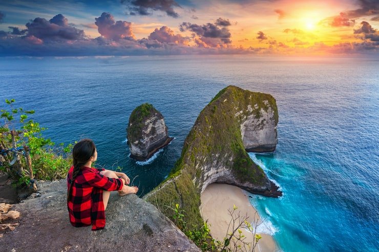 woman sitting cliff looking sunset kelingking beach nusa penida island bali indonesia 335224 340